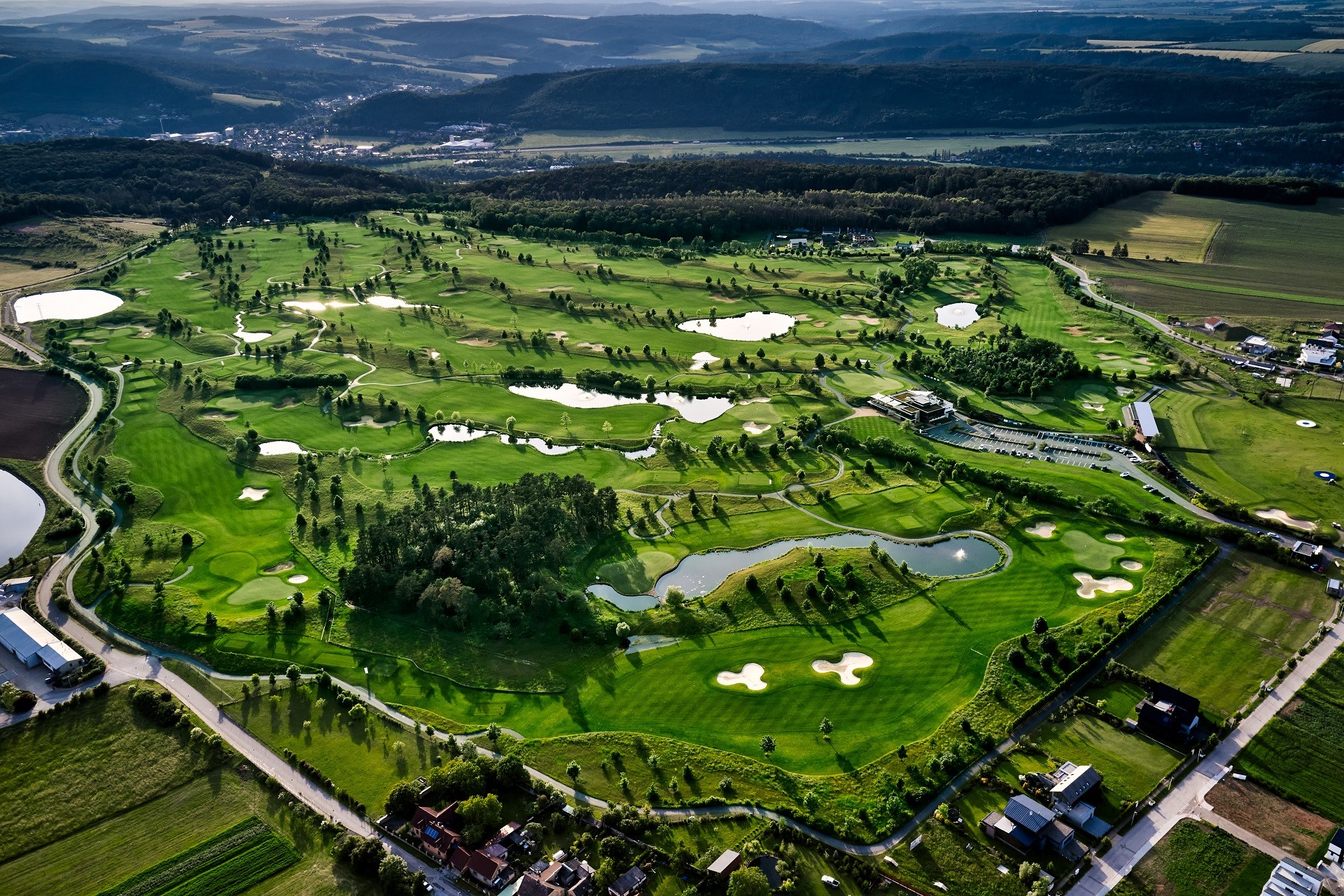 Flygvy över Albatross Golf Resort nära Prag med gröna fairways och vita bunkrar