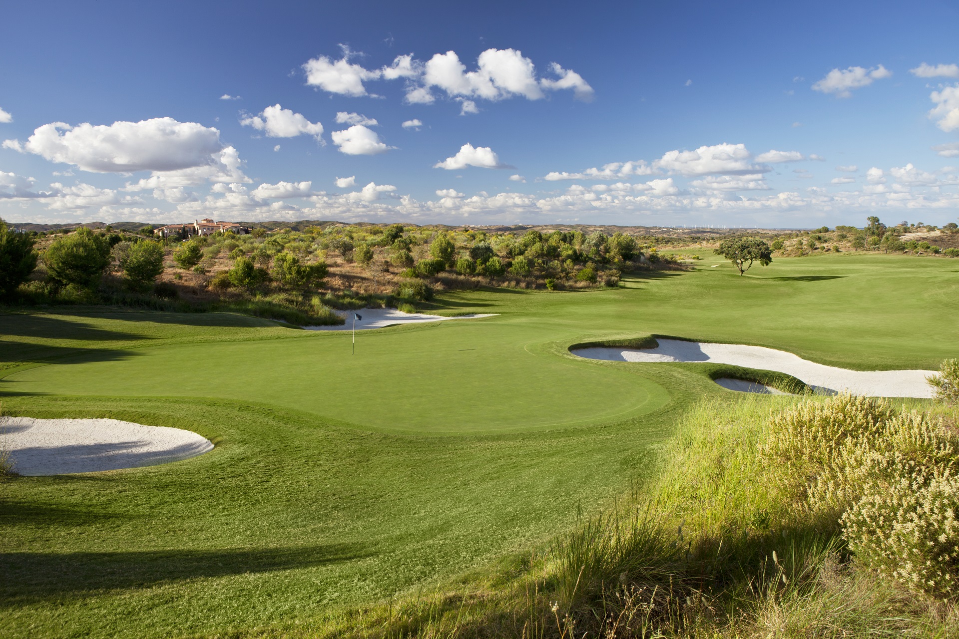 Grön fairway, träd och blå himmel på Monte Rei i Algarve, Portugal