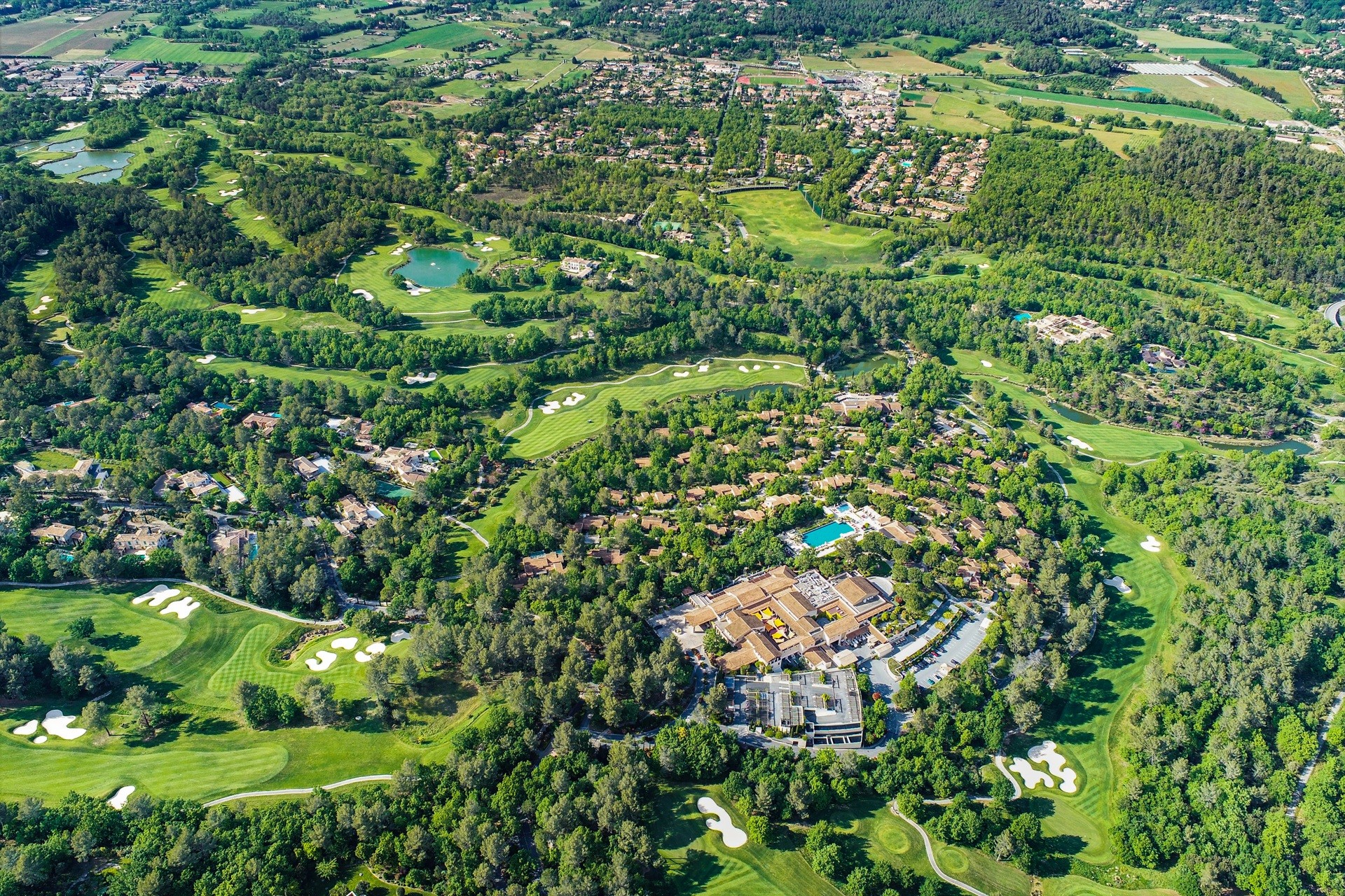 Flygvy över Terre Blanche i Provence med golfbanor och boende bland gröna träd